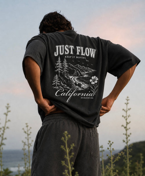 California Hibiscus Heavyweight Tee in washed black, back print, coastal bluff at sunset
