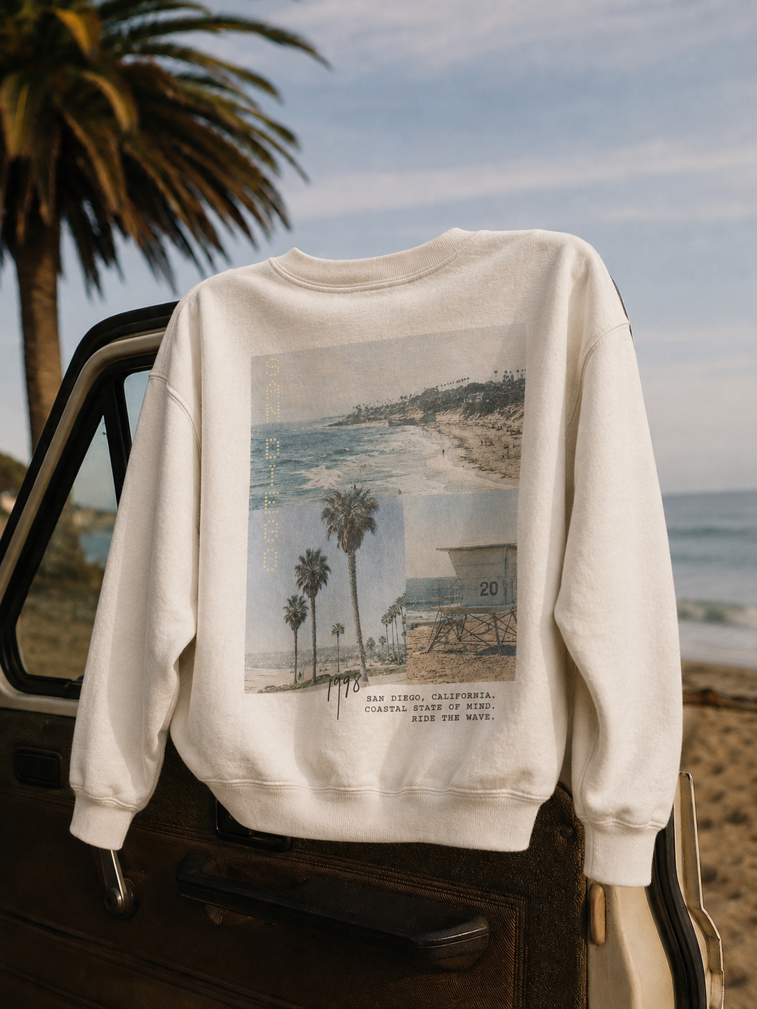 San Diego 98 Crew Sweatshirt in white, on a truck tailgate at the beach