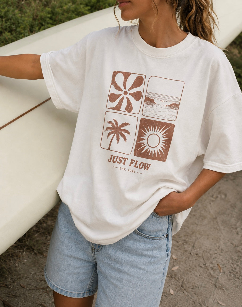Retro Grid Oversized Tee in vintage white, worn with a surfboard at the beach