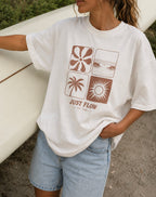 Retro Grid Oversized Tee in vintage white, worn with a surfboard at the beach