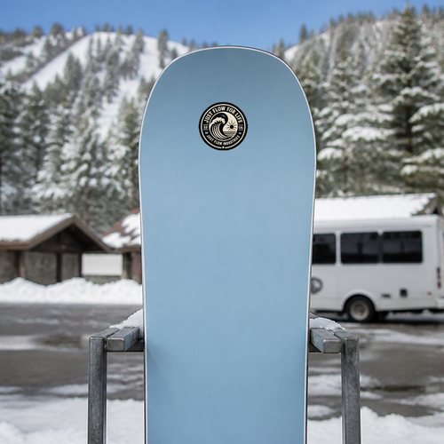 Circular Wave Crest sticker, bone crest on black, on a soft-blue snowboard