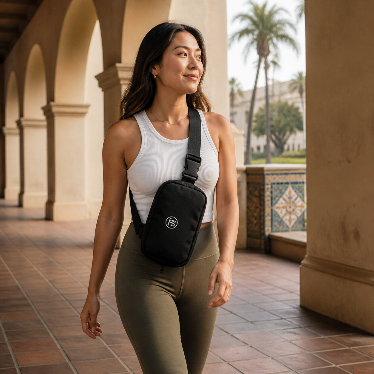 JFI Monogram Sling Bag in black, worn across the chest at Balboa Park