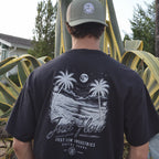 After Dark Heavyweight Tee in washed black, back print worn in a San Diego agave garden