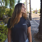 Minimal Wordmark Heavyweight Tee in charcoal, worn on a palm lined San Diego street