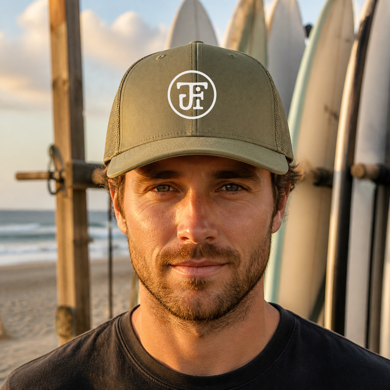 JFI Monogram Trucker Cap in Loden, surf racks at the beach