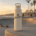 Palm Script sticker on a cream water bottle, SoCal beach