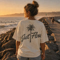 Washed light palm script tee walking the jetty at golden hour