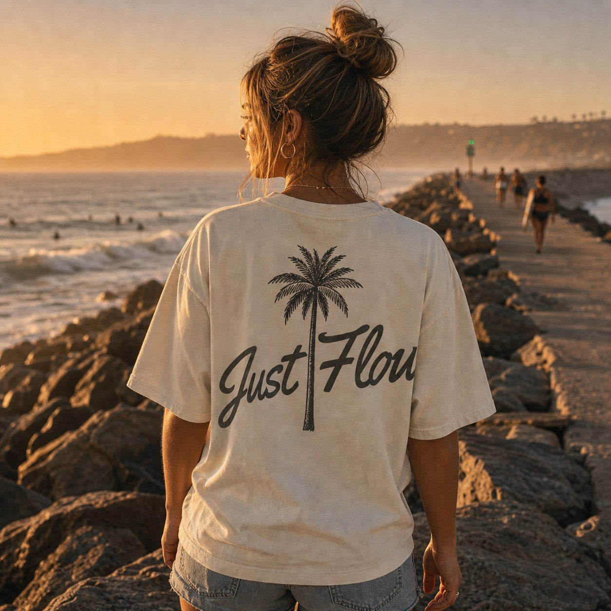 Washed light palm script tee walking the jetty at golden hour