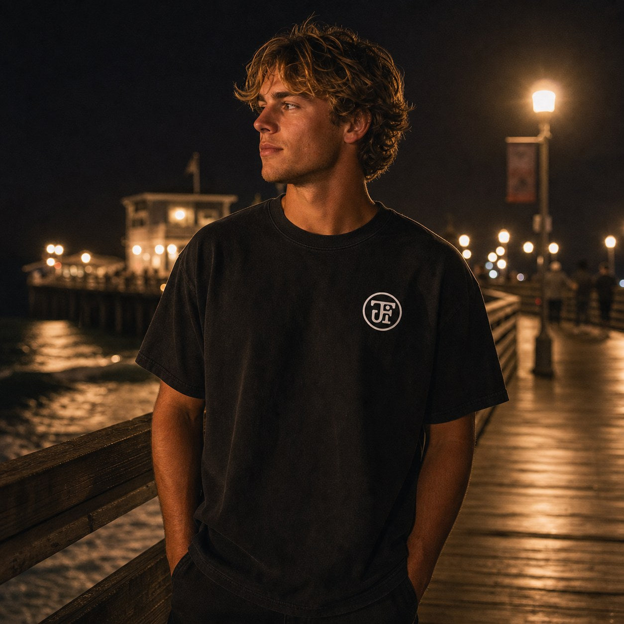 Washed black monogram tee on the pier at night