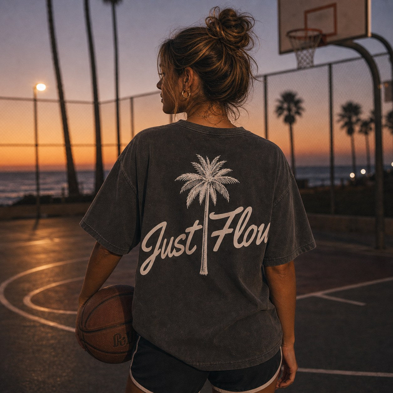 Washed pepper palm script tee on a beach basketball court